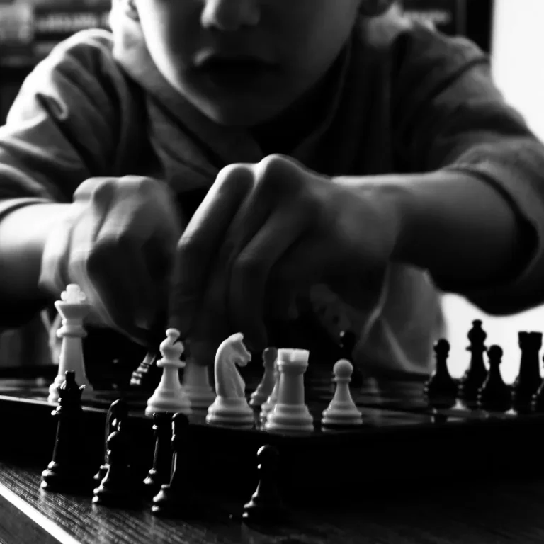 In a metaphor for tax strategies, a person thoughtfully moves chess pieces, symbolizing strategic planning for business owners.