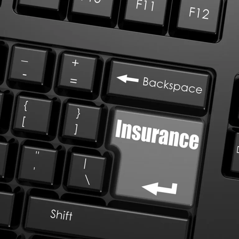 A keyboard features an oversized key labeled "Insurance," suggesting the concept of umbrella insurance coverage as essential.