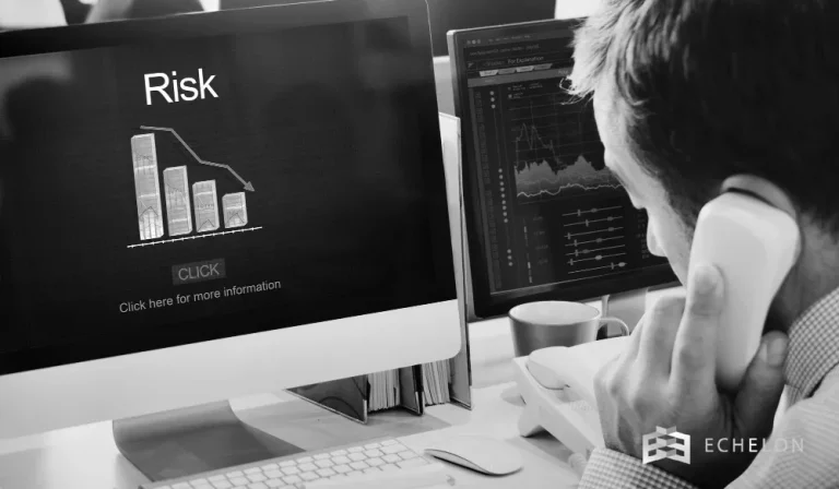 A person on the phone views risk analysis graphs on a computer screen, related to investment grade bonds, with emphasis on declining charts.