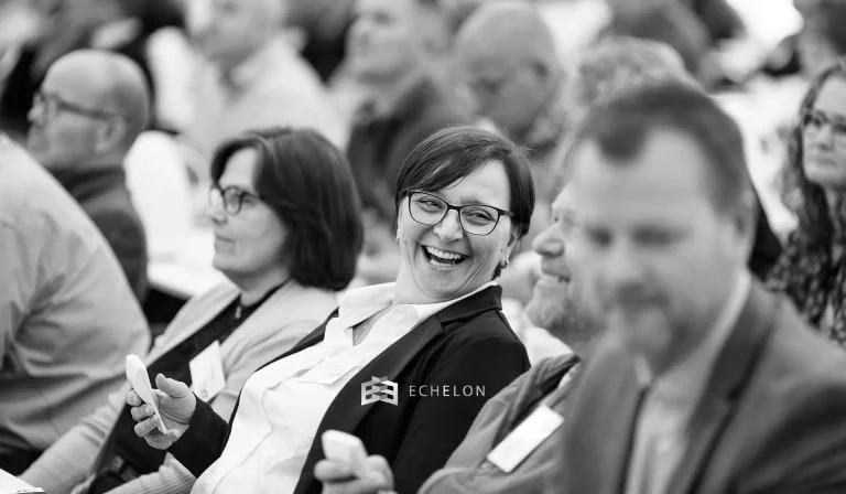 A group of people, including a woman smiling, attend a seminar discussing the 401k contribution limits for 2026.