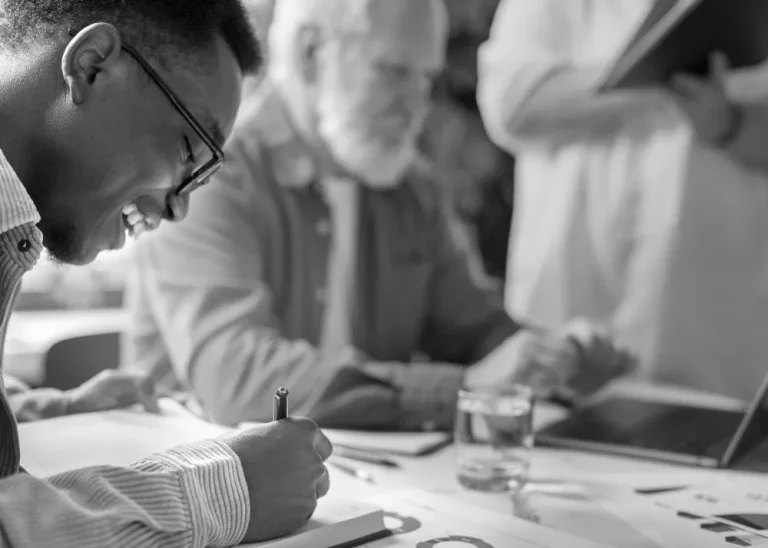 People are working together at a table with documents and graphs, focusing on financial concepts like net unrealized appreciation.