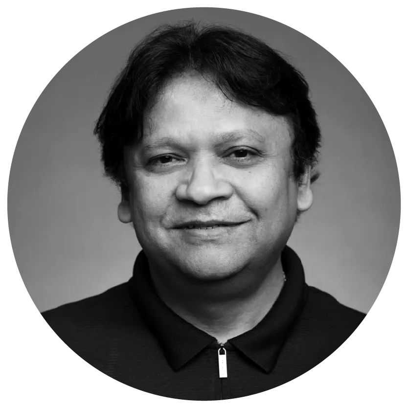 Black and white portrait of a person with medium-length hair, smiling slightly, wearing a dark collared shirt.
