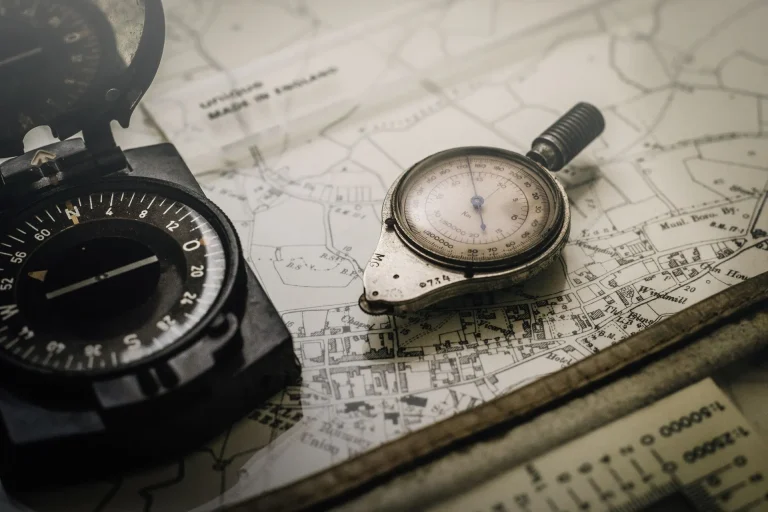A vintage compass and barometer rest on a detailed map, symbolizing strategic navigation and precision in high net worth financial planning and wealth management.