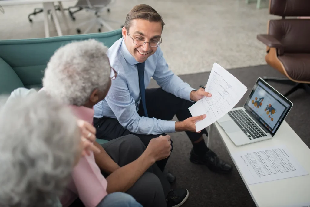 A financial advisor discusses documents with a couple in an office setting, reflecting wealth management services in Austin.